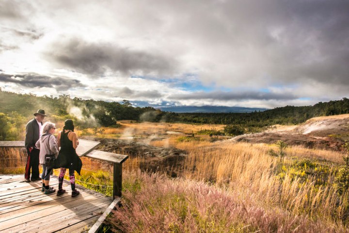 a man standing on top of a grass covered field